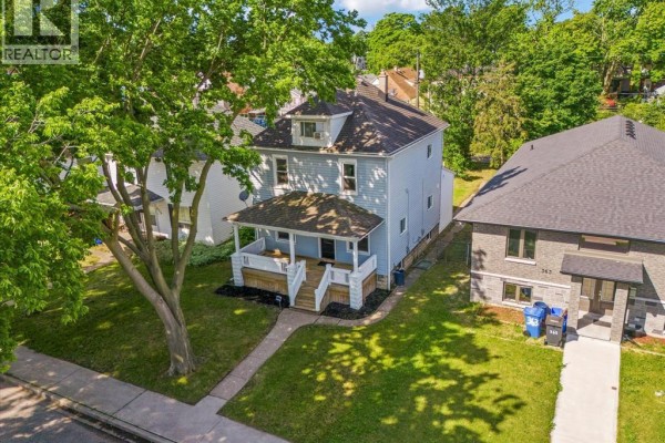 Aerial view of a light blue two-story house with a large tree in the front yard. - 371 Curry, Windsor