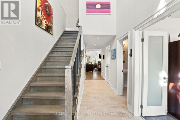 Interior foyer with a staircase, tiled floor, and view into living area. - 3710 Crystal Beach Drive N, Fort Erie
