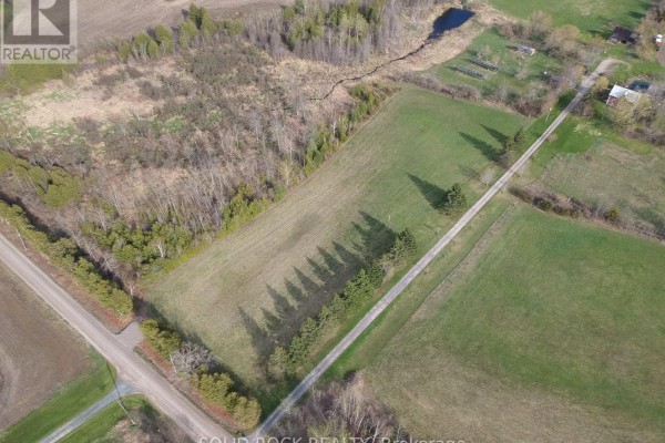 High angle view of undeveloped land featuring fields, a stream, trees, and rural landscape beyond. - 3711 10th Line East, Trent Hills