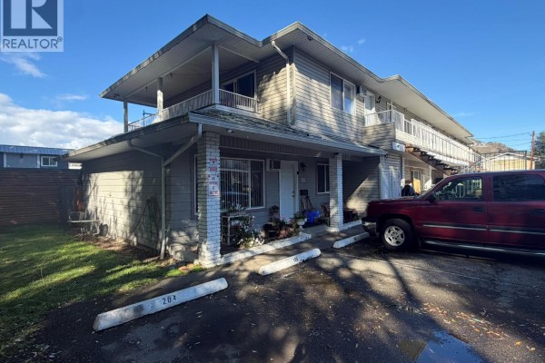 Exterior of a two-story townhouse complex with beige siding and white trim. - 3712 24 Avenue Unit# 105, Vernon