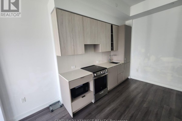 Modern kitchen with light wood cabinets, stainless steel appliances, and a light countertop. - 3713 - 3883 Quartz Road, Mississauga