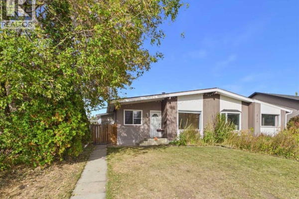 Front view of duplex with walkway, lawn, trees, and blue sky. - 3720 44 Street, Red Deer