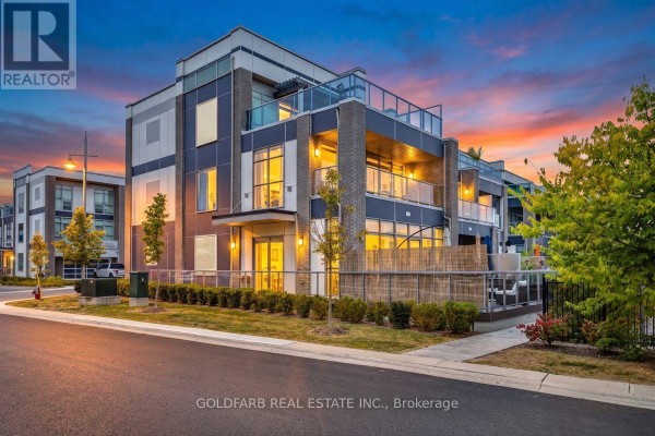 Exterior of modern townhouse at dusk with brick and glass facade. - 3725 Ferretti Court, Innisfil