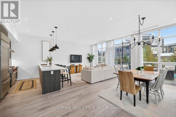 Open-concept living, dining, and kitchen area with island and large windows. - 3725 Ferretti Court, Innisfil
