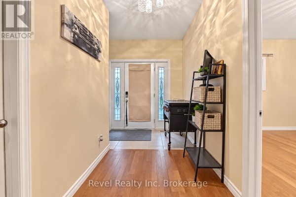 Interior hallway with wood floors, coat rack, shelving, and double glass doors. - 373 First Avenue E, North Bay