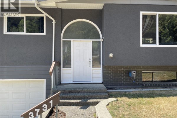 Close-up of the arched entryway with a white door and sidelights. - 3731 Fowlie Cres, Port Alberni