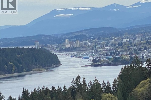 Panoramic view of Nanaimo harbor and city skyline with distant mountains. - 3733 Belaire Dr, Nanaimo