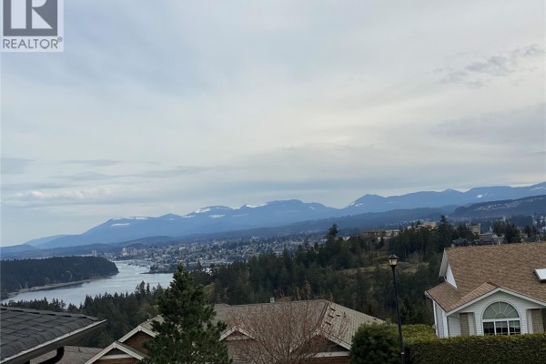 Overhead view of Nanaimo harbor and city, bordered by trees and houses. - 3733 Belaire Dr, Nanaimo