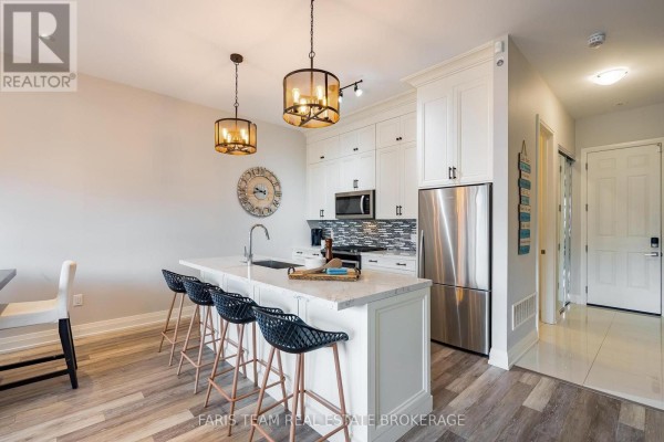 Contemporary kitchen with white cabinets, stainless steel appliances, and an island. - 3733 Riva Avenue, Innisfil
