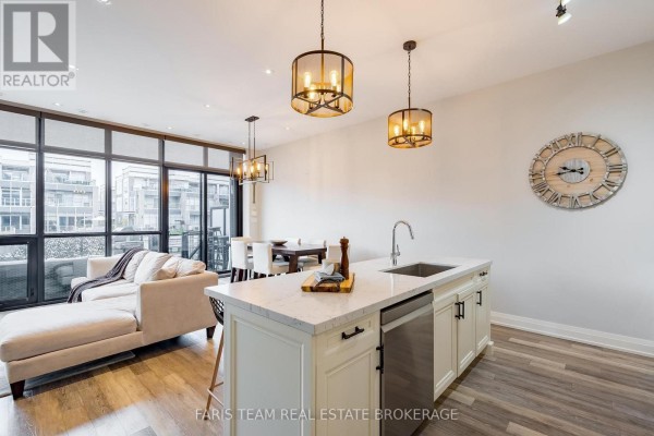 Open-concept living and dining area with a kitchen island and large windows. - 3733 Riva Avenue, Innisfil