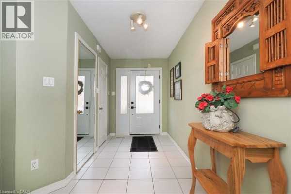 Entryway with tiled floor, pale green walls, and mirrored closet doors. - 375 Holiday Inn Drive Unit# 34, Cambridge