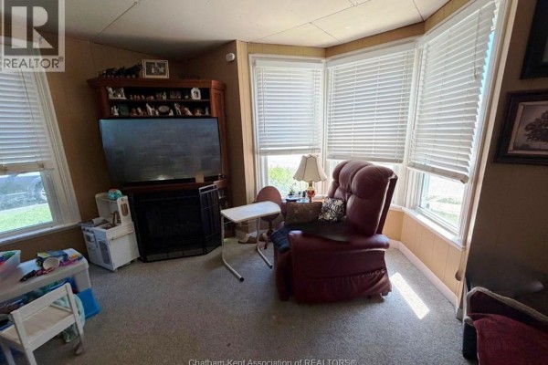 Bedroom with a wooden bed frame, a quilt, a nightstand, and a dog on the bed. - 376 Brown Street, Dresden