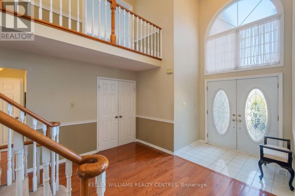 Interior foyer with a grand staircase, double front doors, and a second-floor balcony overlooking the entrance. - 376 Keith Avenue, Newmarket