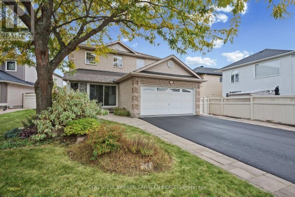 Side exterior view of the house showing landscaping and a paved walkway to the garage. - 3766 Mountain Meadows Crescent, Ottawa