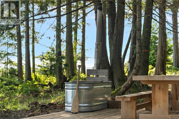 Unfinished two-story structure and a large tent set up in a wooded area. - 377 Evergreen Lane, Sidney Island