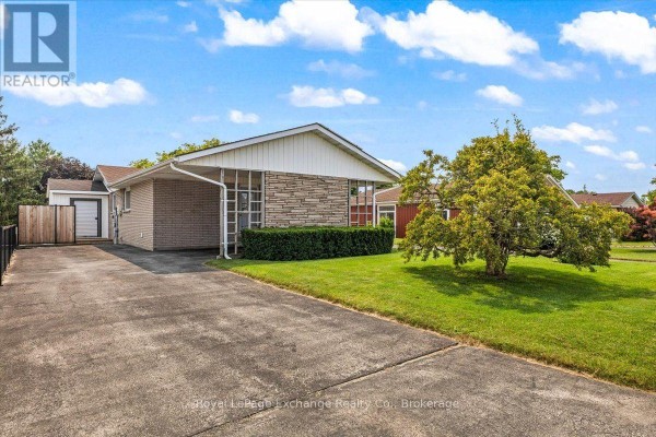 Side view of a brick house with a concrete driveway and manicured lawn. - 377 Princes Street S, Kincardine