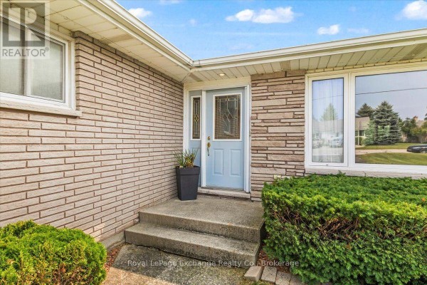 Front entrance of a brick house with a light blue door and stone accents. - 377 Princes Street S, Kincardine