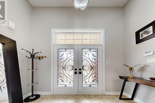 Double front doors with decorative glass panels and a small chair beside them. - 378 Malboeuf Court, Milton