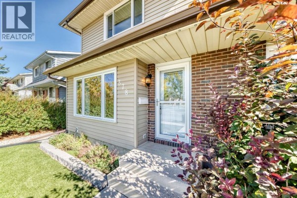 Close-up of the front entrance of the duplex with brick accents. - 378 Midridge Drive Se, Calgary