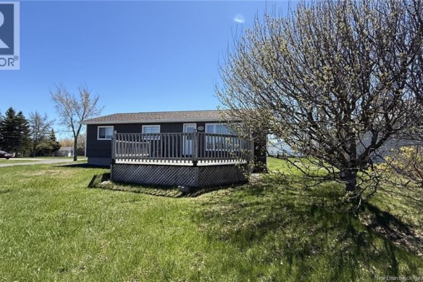 Kitchen with cream cabinets, tiled floor, white appliances, and a dark wood table. - 378 Rue De L'ile, Caraquet