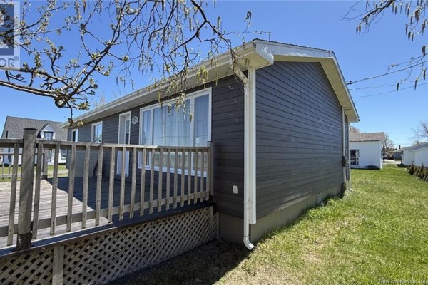 Exterior view of a white detached garage with a roll-up door and a side door. - 378 Rue De L'ile, Caraquet