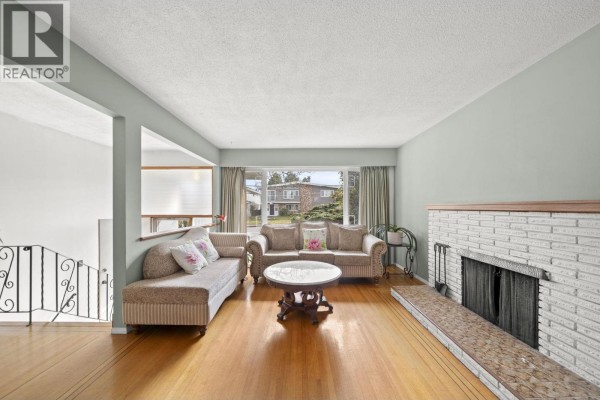 Dining area with a chandelier, sliding glass doors to a covered deck, and hardwood floors. - 3783 Price Street, Burnaby