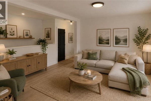 Living room with sectional sofa, coffee table, armchair, and framed landscape art on wall. - 379 Main Street Unit# 3, Woodstock