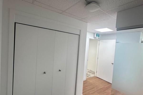Interior view of a hallway with bi-fold doors and a frosted glass partition. - 379 Parkview Road, Yorkton