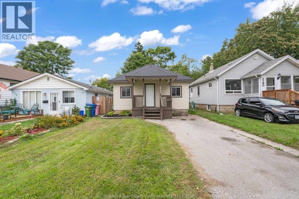 Street view of a beige bungalow with a driveway and neighboring houses. - 3796 Glenfield Street, Windsor