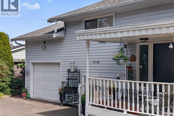 Side view of a light gray house showing the garage door, porch, and exterior siding. - 3798 Laurel Dr, Royston