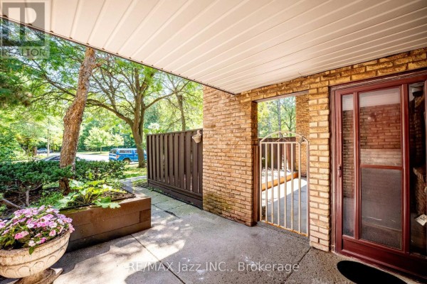 Covered porch area with brick walls, a metal gate, and plants. - 38 - 120 Ling Road, Toronto