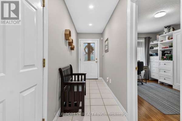 Interior hallway with tiled floor, bench, and door leading to a room. - 38 - 43 Capulet Walk, London North