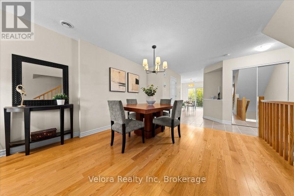 Dining area with a wooden table, four chairs, and hardwood floors. - 494 Leboutillier Avenue, Ottawa