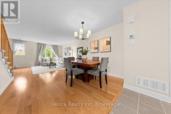 Open concept dining and living area with hardwood floors and neutral walls. - 494 Leboutillier Avenue, Ottawa