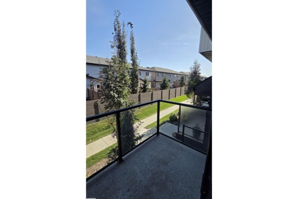 View from the balcony of neighboring townhouses, fence, and green space. - #38 1729 Keene Cr Sw Sw, Edmonton
