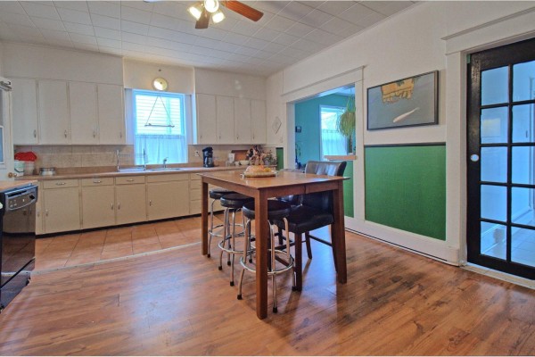 Kitchen with white cabinets, wooden floors, and a large island with seating. - 38-40 Rue Broad, Gatineau
