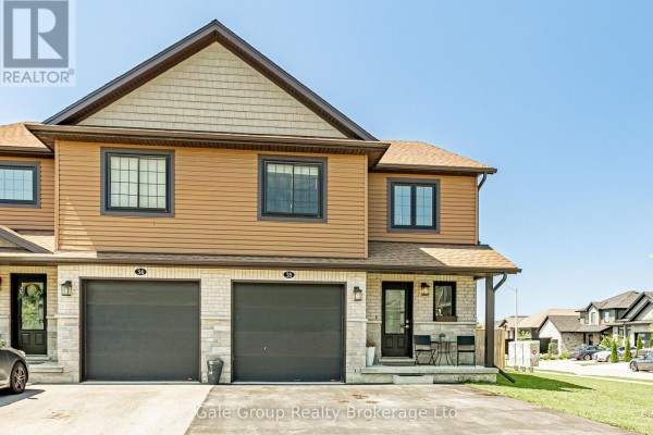 Front exterior of a townhouse featuring two garage doors, a front entrance, and stone facade. - 38 Amber Street, Norfolk