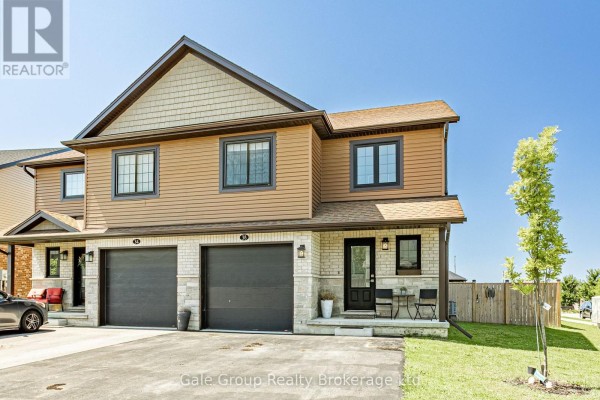 Side view of a townhouse with attached garages, a front porch, and wood fencing. - 38 Amber Street, Norfolk