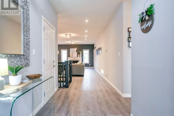 Hallway entrance from foyer showing doors, staircase, and view into living area. - 38 Beverly Street, Springwater