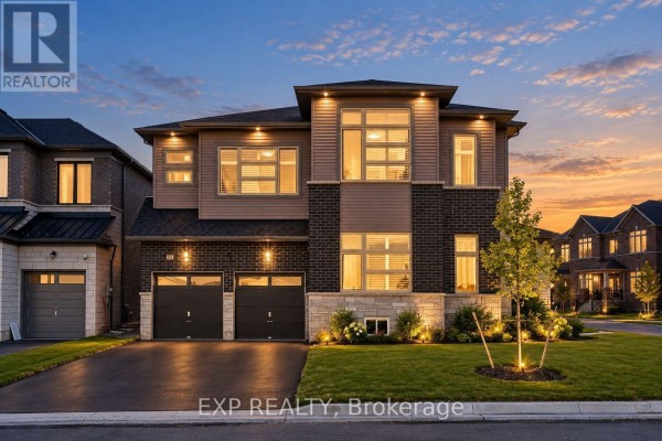 Front exterior of a modern two-story house with a triple-car garage and manicured lawn. - 38 Bud Leggett Crescent, Georgina