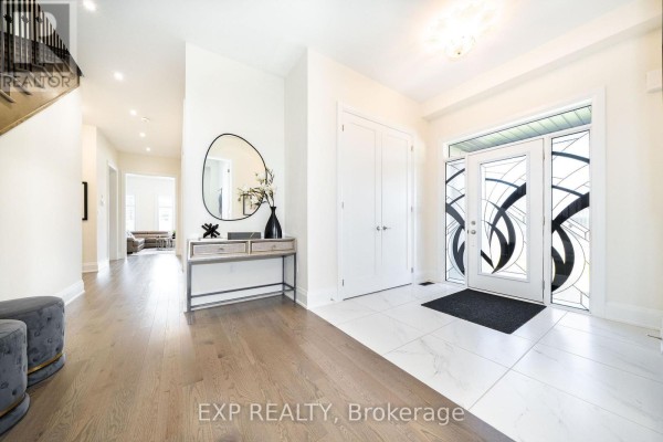 Foyer with white marble tile floors, decorative glass double doors, and a console table. - 38 Bud Leggett Crescent, Georgina