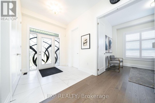 Interior foyer view showing white tile floors, double doors, and an entrance to a living area. - 38 Bud Leggett Crescent, Georgina
