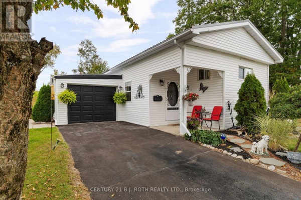 Exterior front view of a white mobile home with a covered carport and attached garage. - 38 Cameron Drive, Oro Medonte