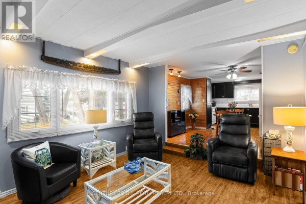 Living room with plush seating, a coffee table, and view into the kitchen area. - 38 Cameron Drive, Oro Medonte