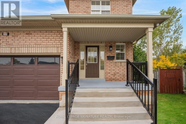 Close-up of the front entrance with brick detailing, porch, stairs, and a brown front door. - 38 Charleswood Circle, Brampton