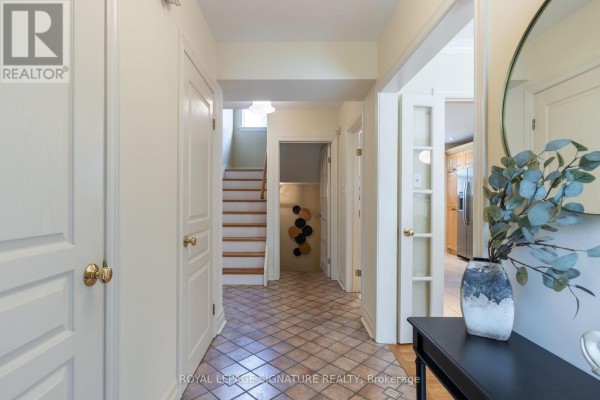 Interior entryway with cream walls, a tiled floor, a staircase, and doors to other rooms. - 38 Danville Drive, Toronto