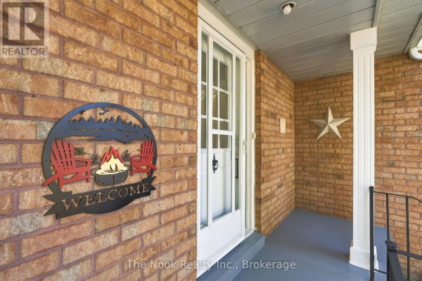 Covered porch entrance of a townhouse with a white door and brick exterior. - 38 Galbraith Court, Clarington