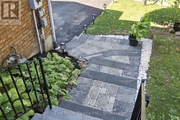 View looking down paved stone stairs and walkway to the driveway of a townhouse. - 38 Galbraith Court, Clarington