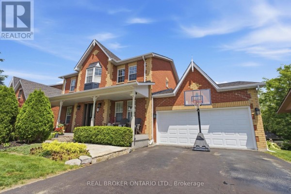Side view of the brick house with a covered porch and a double garage door. - 38 Galloway Crescent, Uxbridge