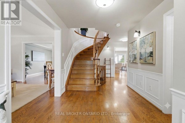 Interior foyer with a curved wooden staircase, hardwood floors, and neutral-toned walls. - 38 Galloway Crescent, Uxbridge